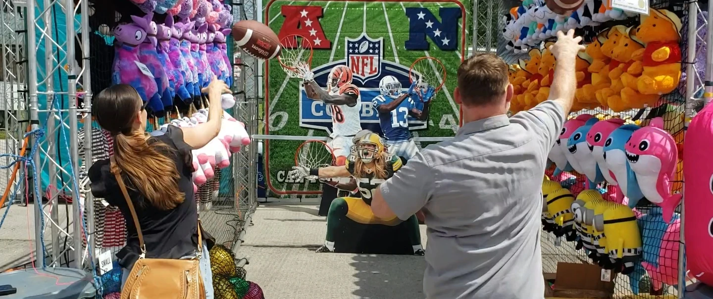 Man and woman playing an amusement concession game at a fair