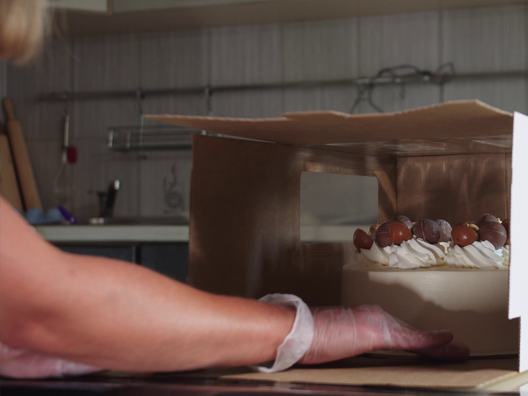 home baker places cake in box